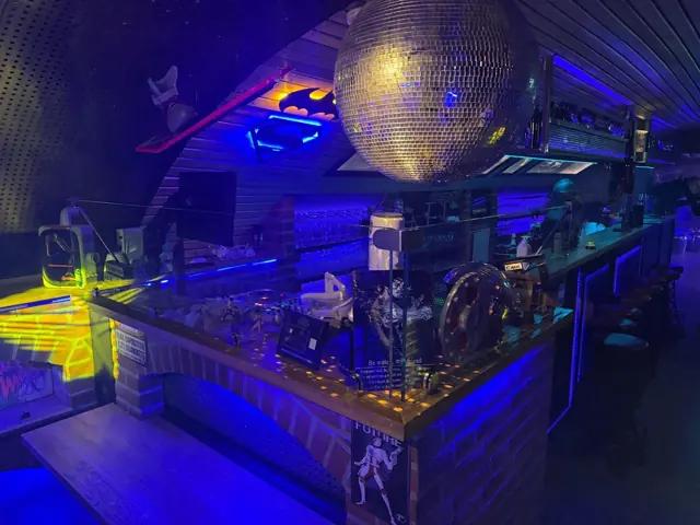 Blau beleuchtete Theke mit großer Discokugel in der Bar Zeitreise Celle