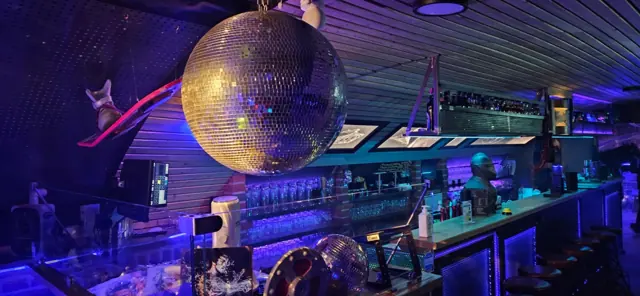 Große Discokugel über der Theke der Bar Zeitreise