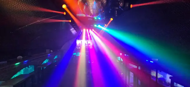 Bunte Lichtstrahlen und Discokugel in der Bar Zeitreise