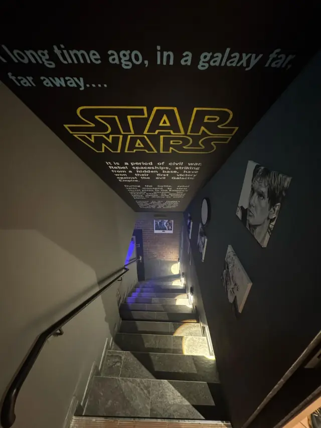 Treppenaufgang mit Star-Wars-Schriftzug an der Wand der Bar Zeitreise