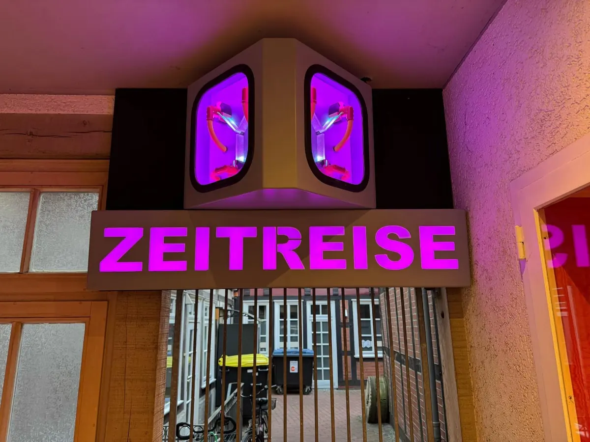 Leuchtendes pinkes Zeitreise-Neonschild am Eingang der Bar in Celle